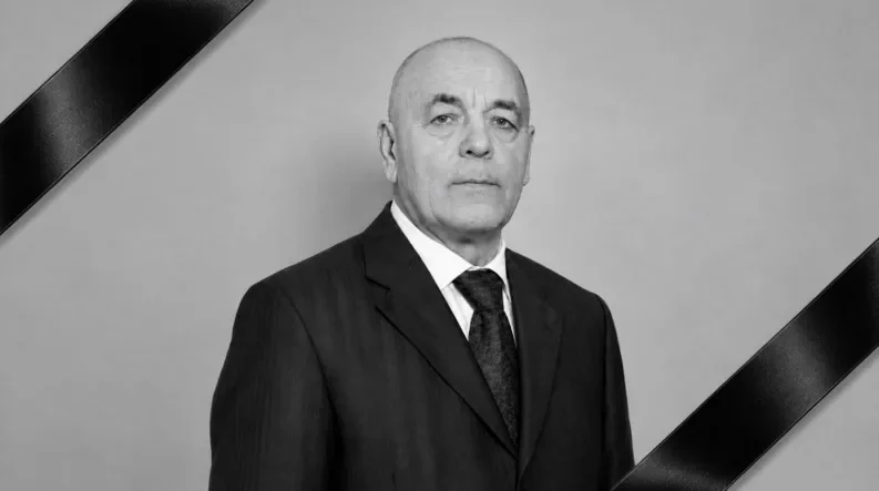 Чорно-білий портрет лисого чоловіка в костюмі з траурними стрічками